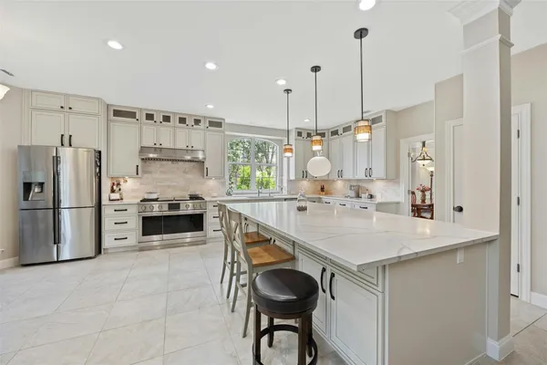 a kitchen with stainless steel appliances white cabinets and a window
