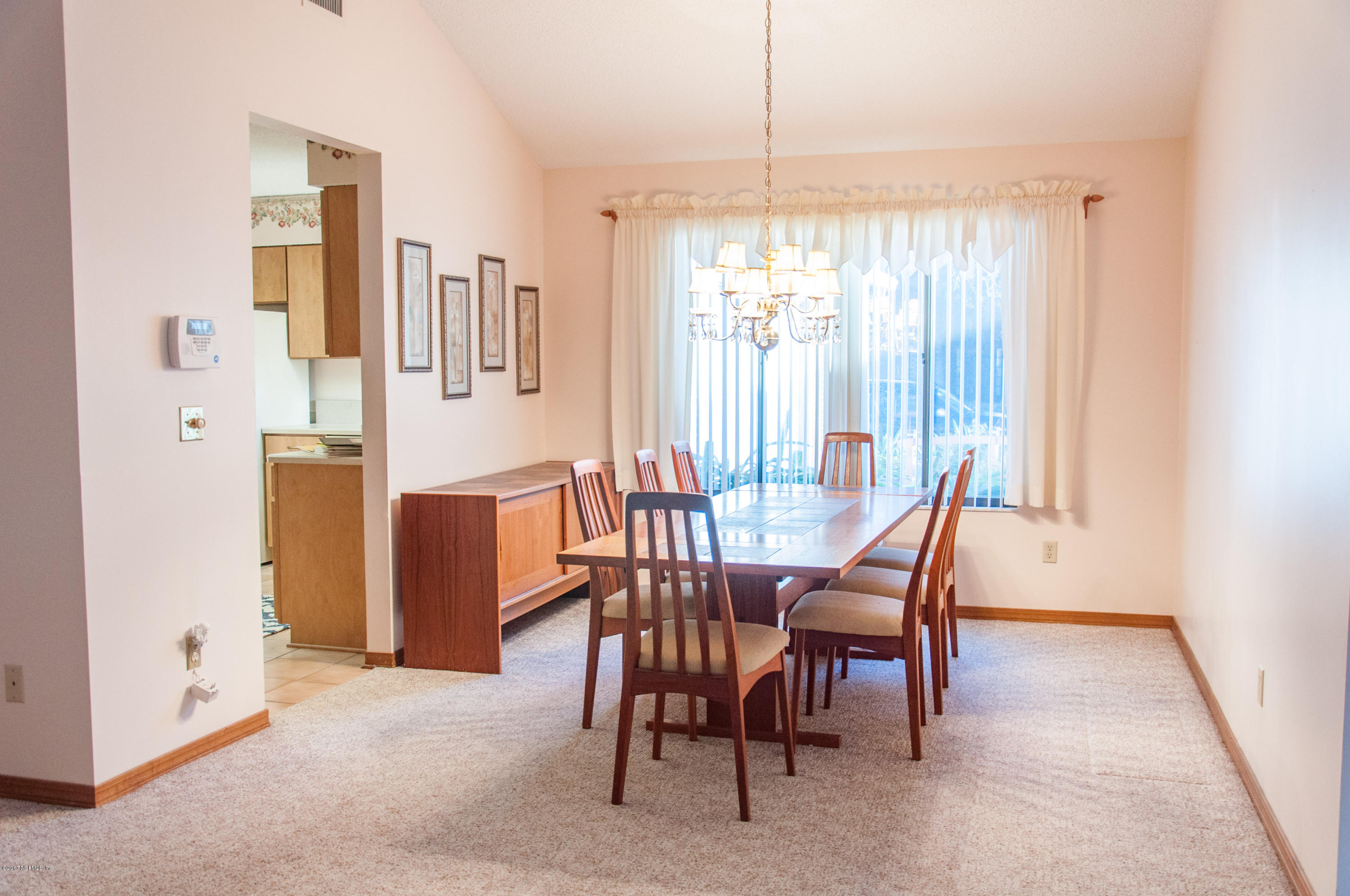 5461 Spring Brook Road Jacksonville, FL 32277 - Photo 11 of 38 a view of a dining room with furniture and chandelier