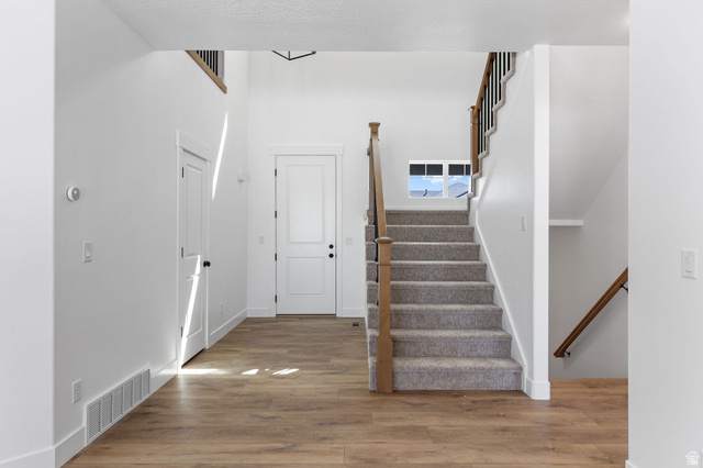 1144 South 4475 West West Point, UT 84015 - Photo 3 of 30 Entryway featuring wood-finish flooring and a carpeted staircase with wood and metal railings