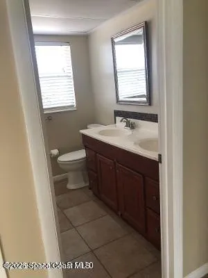 a bathroom with a sink a toilet and a window