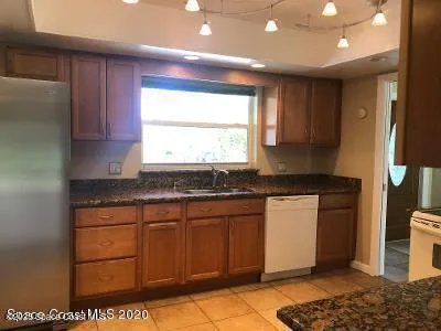 a kitchen with stainless steel appliances granite countertop a sink a stove a refrigerator and cabinets