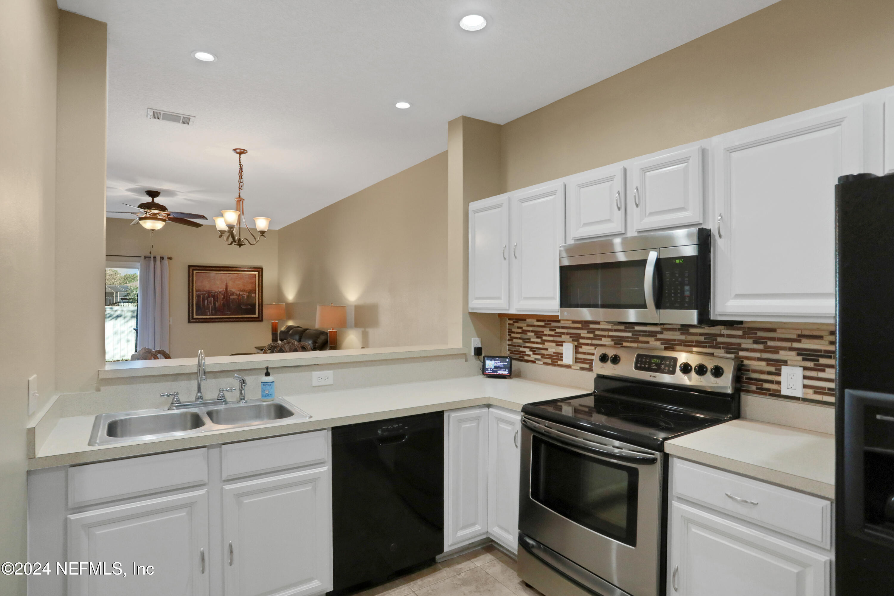 513 Scrub Jay Drive St. Augustine, FL 32092 - Photo 3 of 25 a kitchen with stainless steel appliances a sink stove and microwave