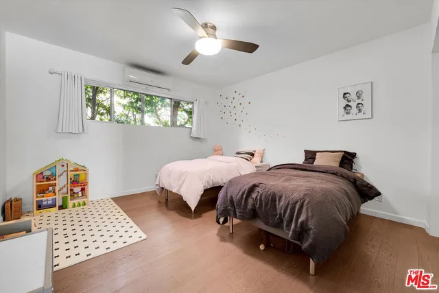 a bedroom with two beds and a window
