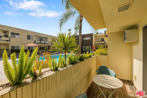 a view of a building with a swimming pool and sitting area
