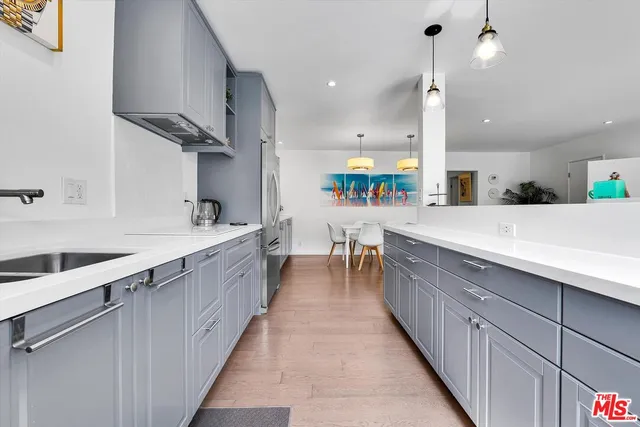 a large kitchen with stainless steel appliances a sink counter top space and cabinets