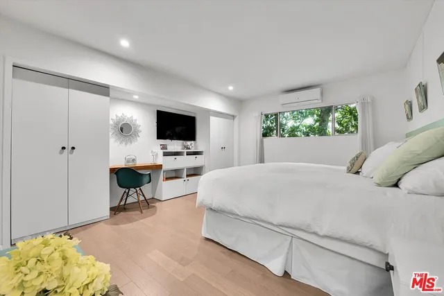 a bedroom with a large bed and a flat screen tv