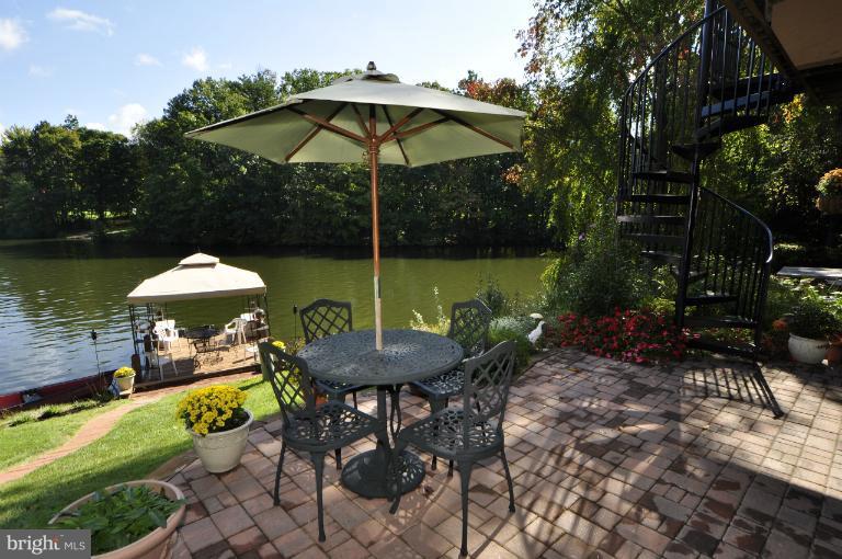 11206 Lagoon Lane Reston, VA 20191 - Photo 20 of 27 a view of a table and chairs under an umbrella in backyard