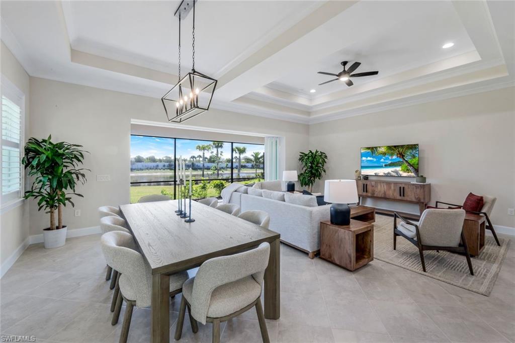 8850 Calypso Court Naples, FL 34113 - Photo 14 of 41 Dining room with a raised ceiling, crown molding, ceiling fan, and light tile patterned floors