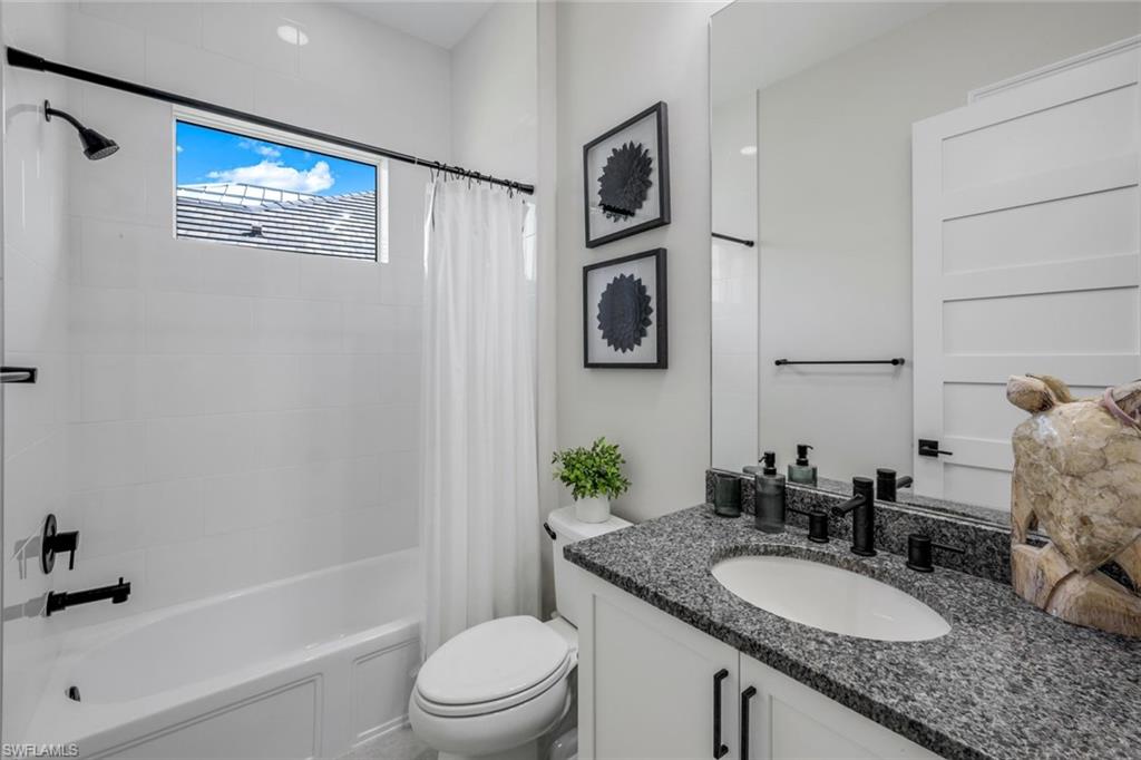 8850 Calypso Court Naples, FL 34113 - Photo 21 of 41 Full Guest Bathroom with glass-enclosed shower/tub combo and vanity