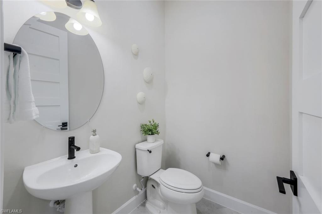 8850 Calypso Court Naples, FL 34113 - Photo 23 of 41 Half bathroom with baseboards and tile patterned flooring