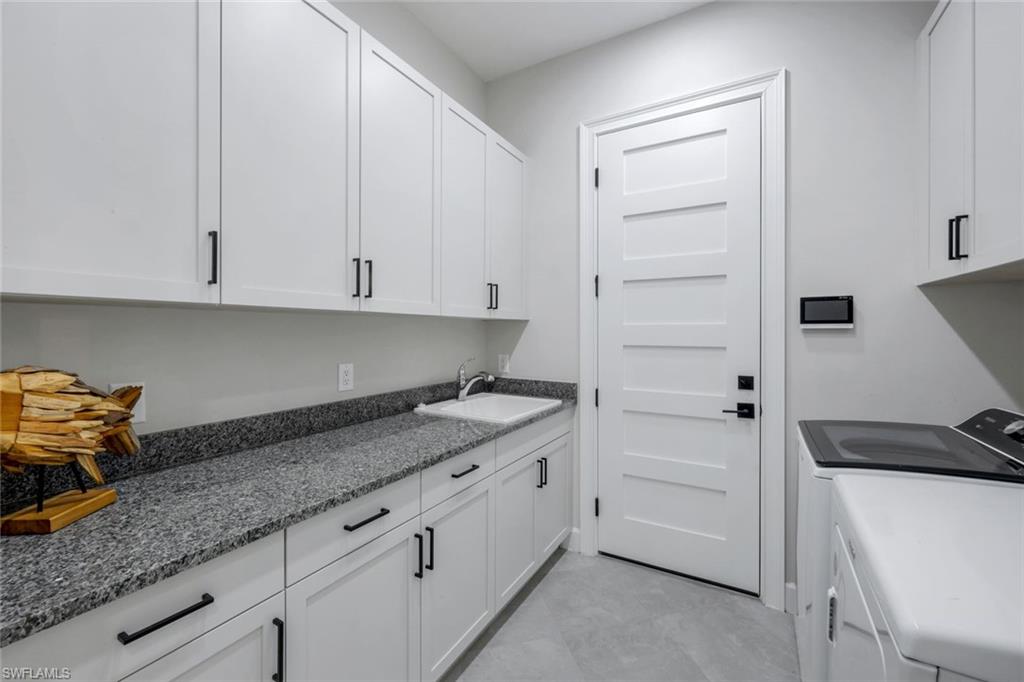 8850 Calypso Court Naples, FL 34113 - Photo 25 of 41 Laundry room with cabinet space and washer and dryer