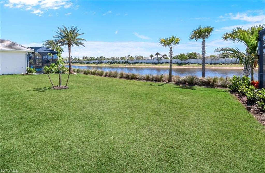 8850 Calypso Court Naples, FL 34113 - Photo 28 of 41 View of green lawn featuring a water view and a lanai
