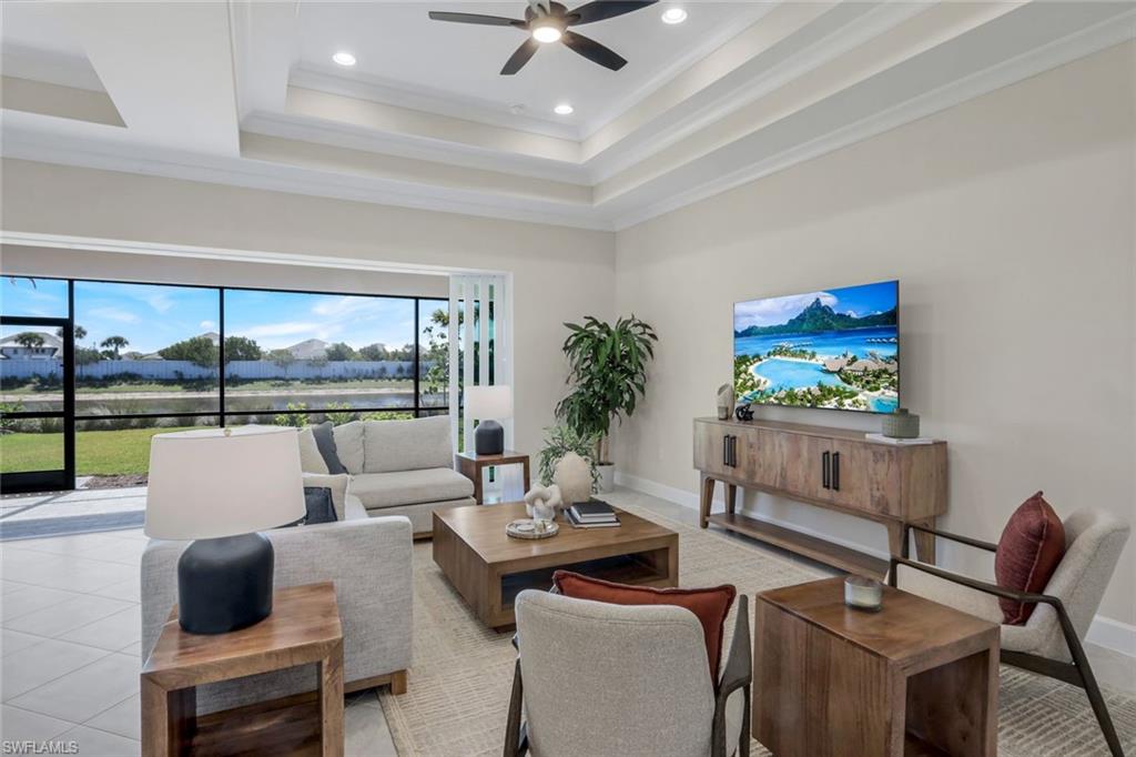 8850 Calypso Court Naples, FL 34113 - Photo 8 of 41 Living area featuring a raised ceiling, recessed lighting, ornamental molding, tile patterned flooring, and a ceiling fan