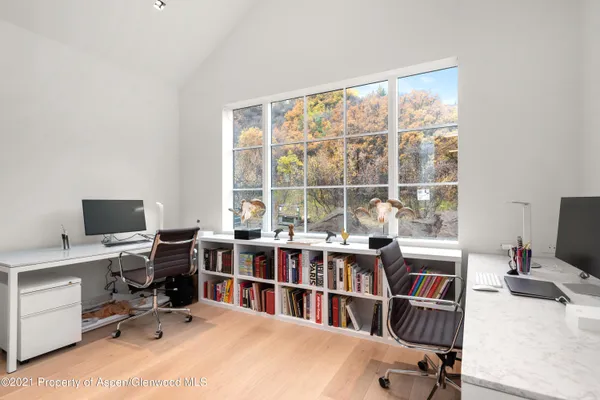 a view of a workspace with furniture and a window