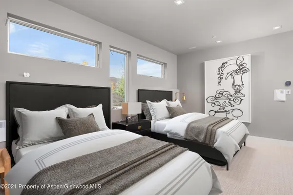 a bedroom with two beds and a painting on the wall