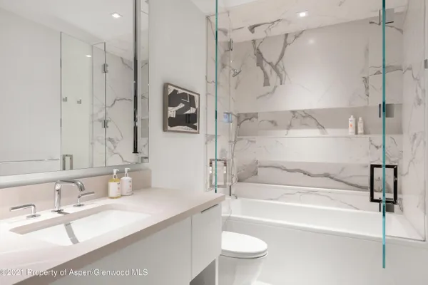 a bathroom with a granite countertop sink mirror toilet and bathtub