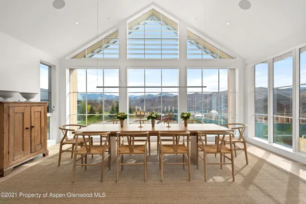 a dining room with furniture large windows and a livingroom