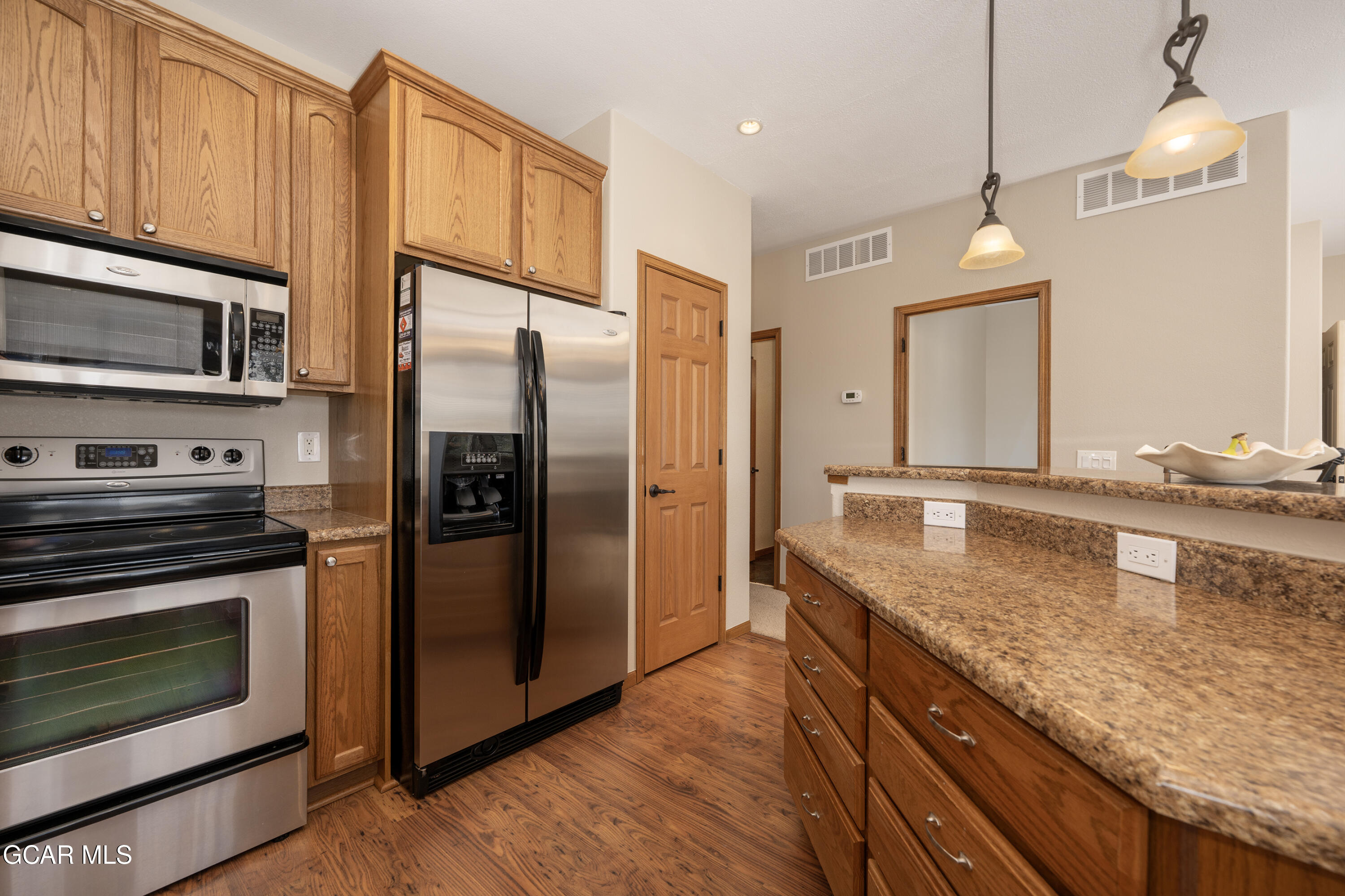 840 Ferret Lane Fraser, CO 80442 - Photo 2 of 33 a kitchen with stainless steel appliances granite countertop a refrigerator a stove and a sink with wooden floor
