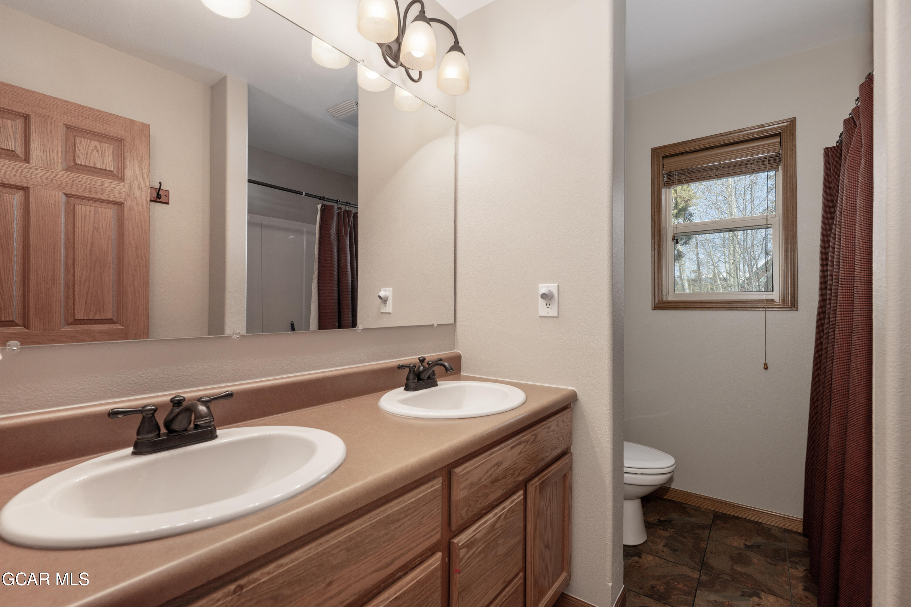 840 Ferret Lane Fraser, CO 80442 - Photo 25 of 33 a bathroom with a granite countertop double vanity sink a mirror and a toilet