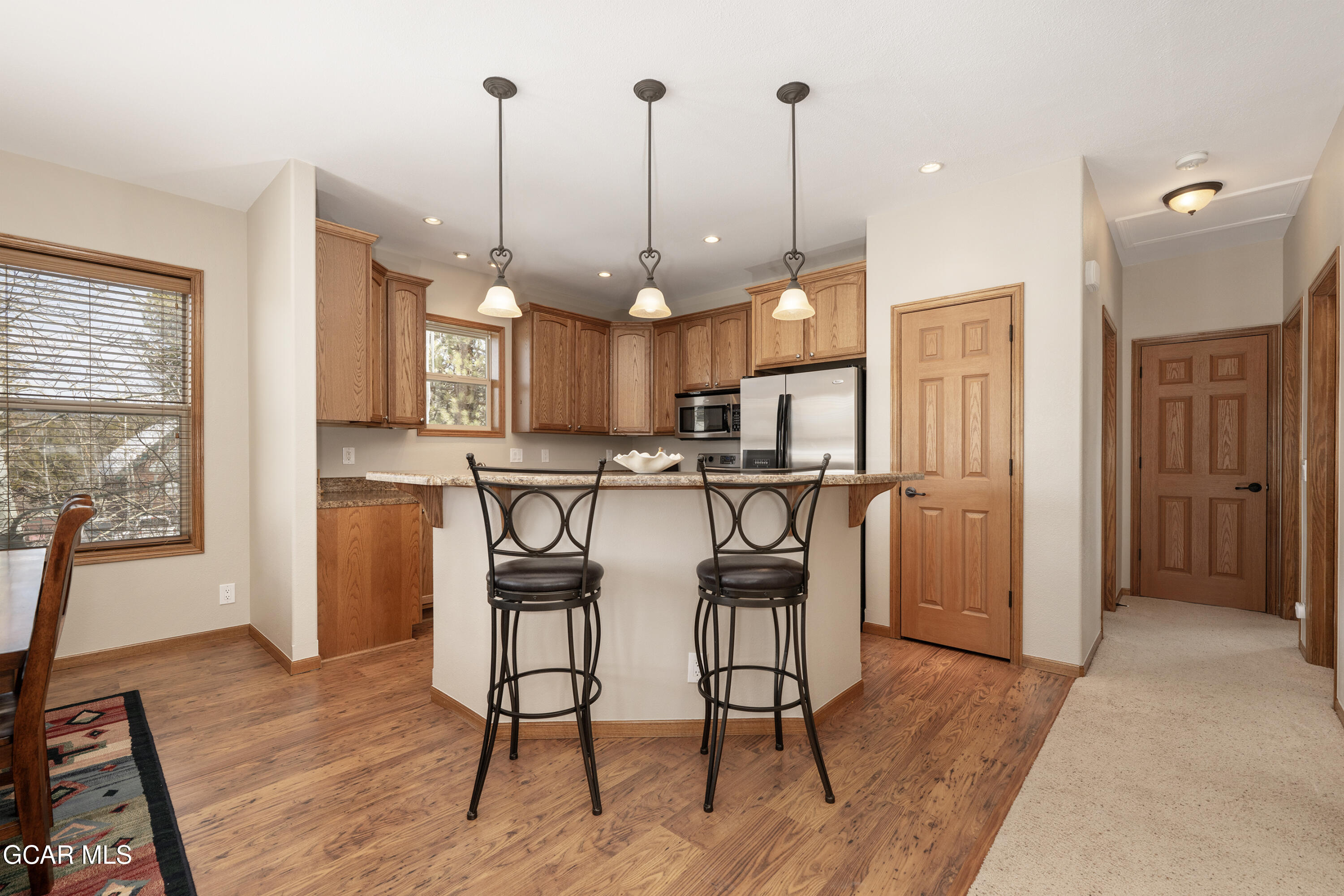 840 Ferret Lane Fraser, CO 80442 - Photo 3 of 33 a open kitchen with stainless steel appliances granite countertop a refrigerator a oven a sink a dining table and chairs with wooden floor