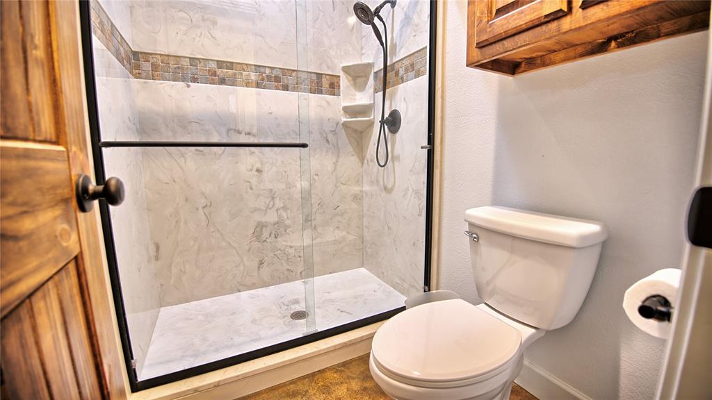 2930 North Greenbrier Road Nocona, TX 76255 - Photo 21 of 40 a white toilet sitting next to a shower