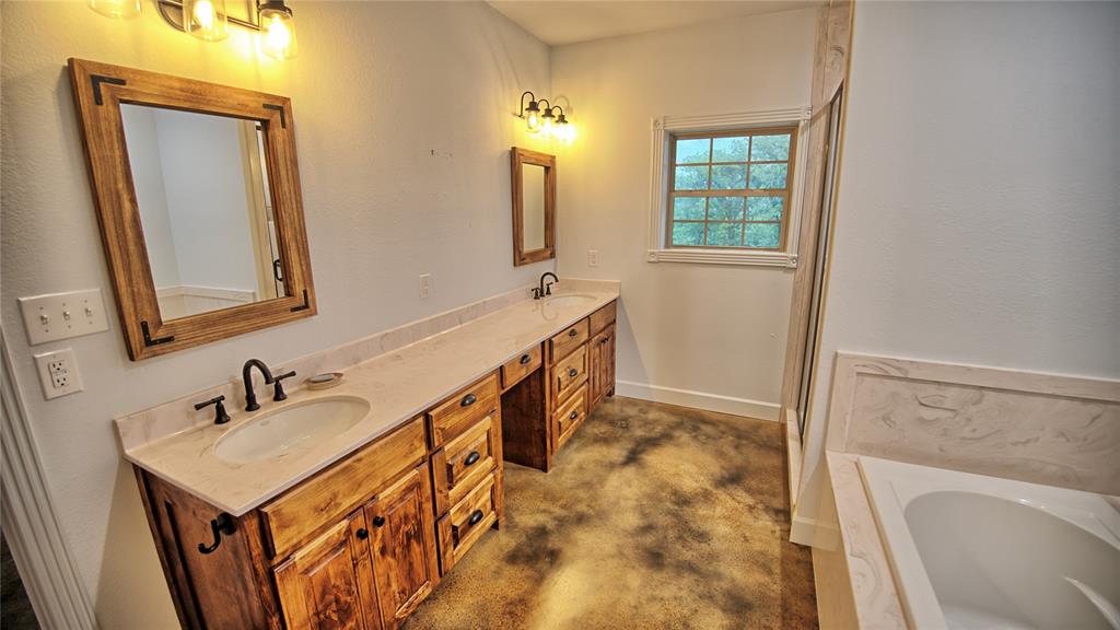 2930 North Greenbrier Road Nocona, TX 76255 - Photo 22 of 40 a bathroom with 2 sink and a mirror