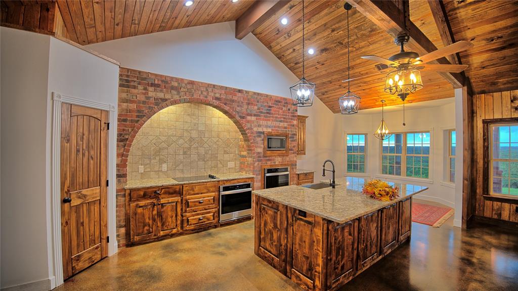 2930 North Greenbrier Road Nocona, TX 76255 - Photo 9 of 40 a view of a kitchen with stainless steel appliances granite countertop a stove and a wooden cabinets