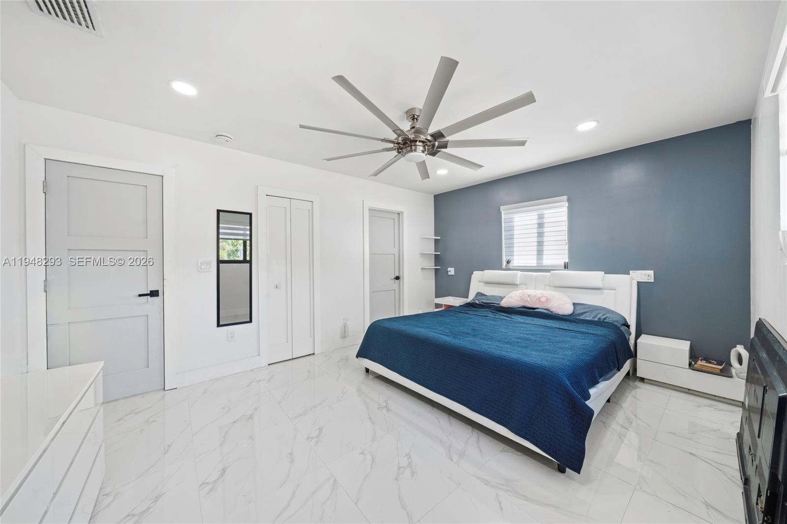 7874 Northwest 175th Street Hialeah, FL 33015 - Photo 11 of 19 a bedroom with a large bed chandelier and a window