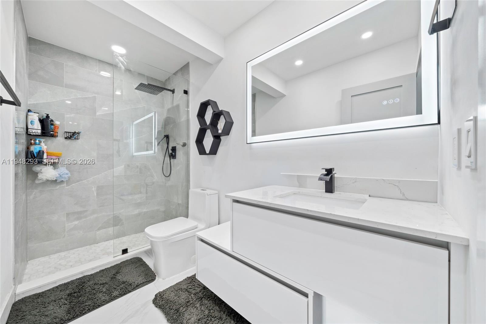 7874 Northwest 175th Street Hialeah, FL 33015 - Photo 12 of 19 a bathroom with a sink a toilet and a shower