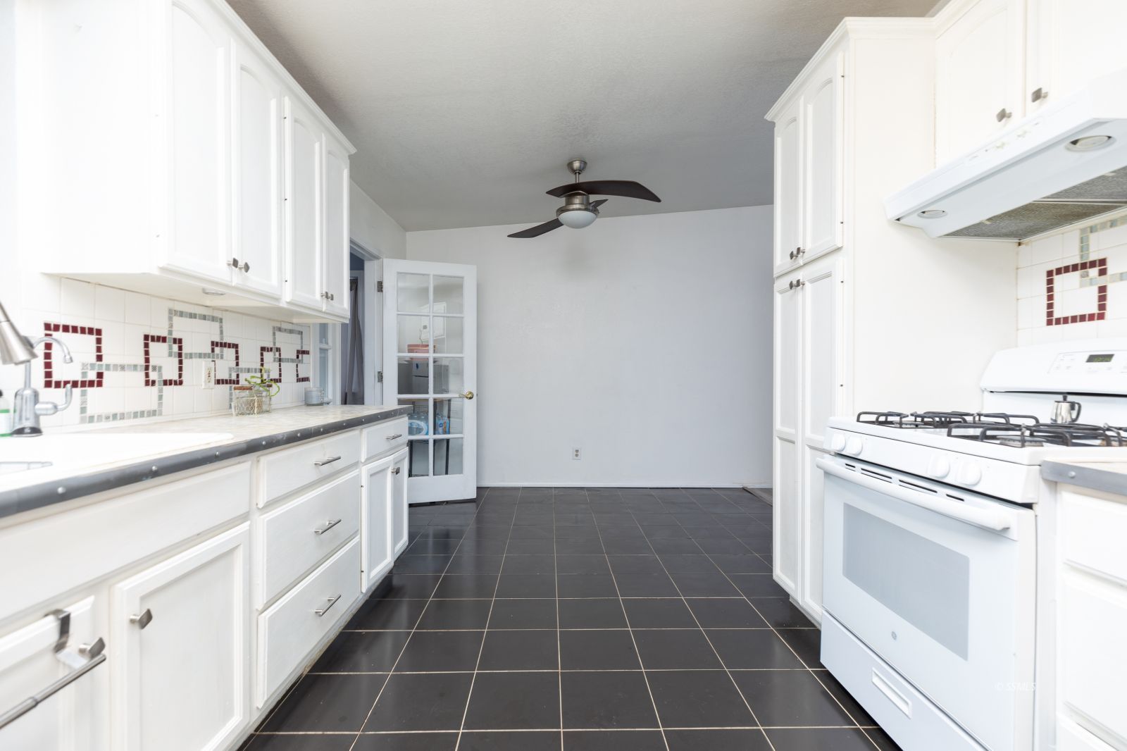 1263 South Primrose Street Ridgecrest, CA 93555 - Photo 12 of 36 a kitchen with a stove top oven sink and cabinets