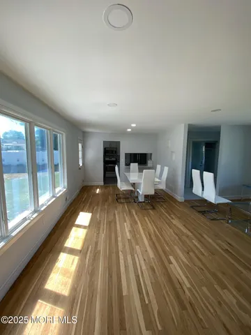 a view of a living room and bedroom with furniture wooden floor and windows