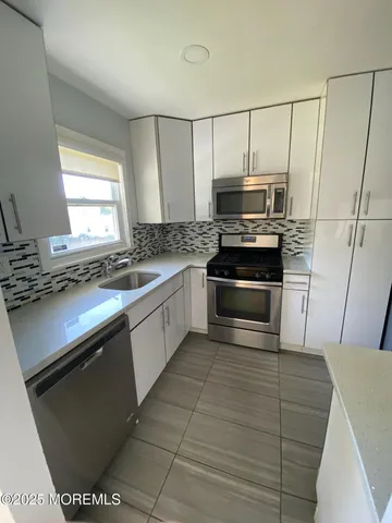 a kitchen with granite countertop a stove and a microwave
