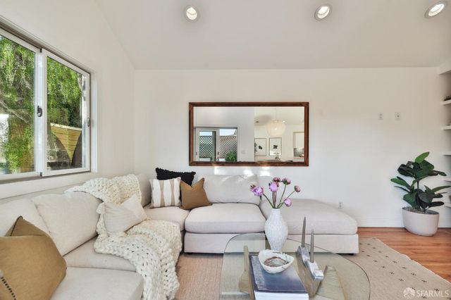 a living room with furniture and a potted plant