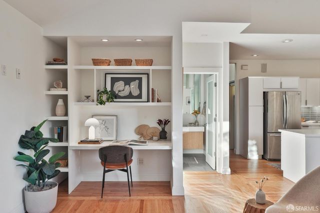 a kitchen with stainless steel appliances kitchen island granite countertop a table chairs in it and wooden floors