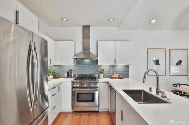 a kitchen with stainless steel appliances a refrigerator sink and cabinets
