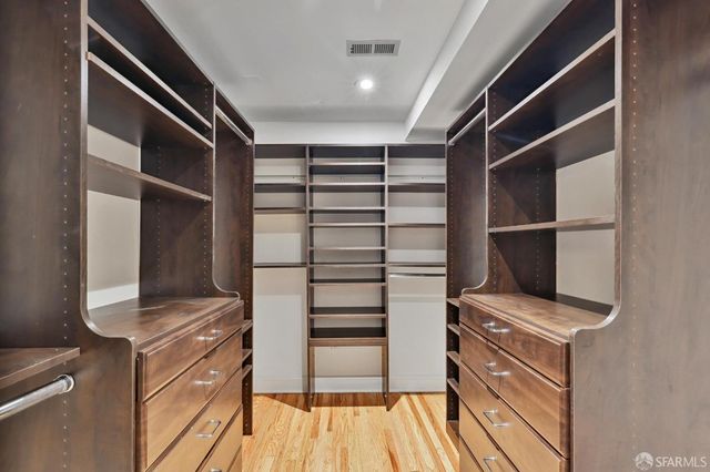 a bedroom with two beds and a large mirror next to a window