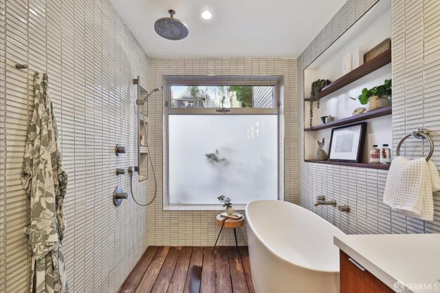 a view of a patio with couches table and chairs with wooden fence and plants