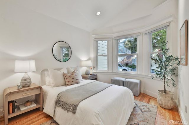 a view of a house with a large window and potted plants