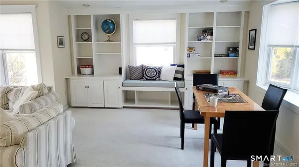 a living room with furniture a table and a large window