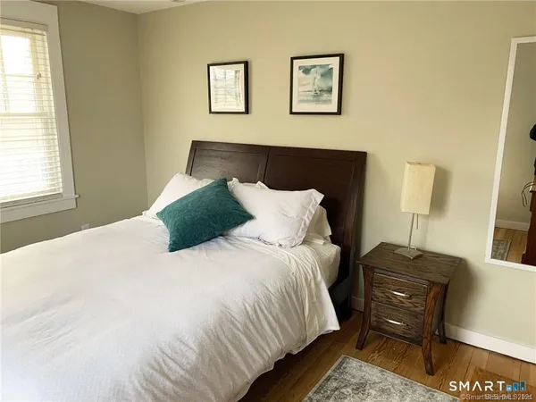 a bedroom with a bed and wooden floor