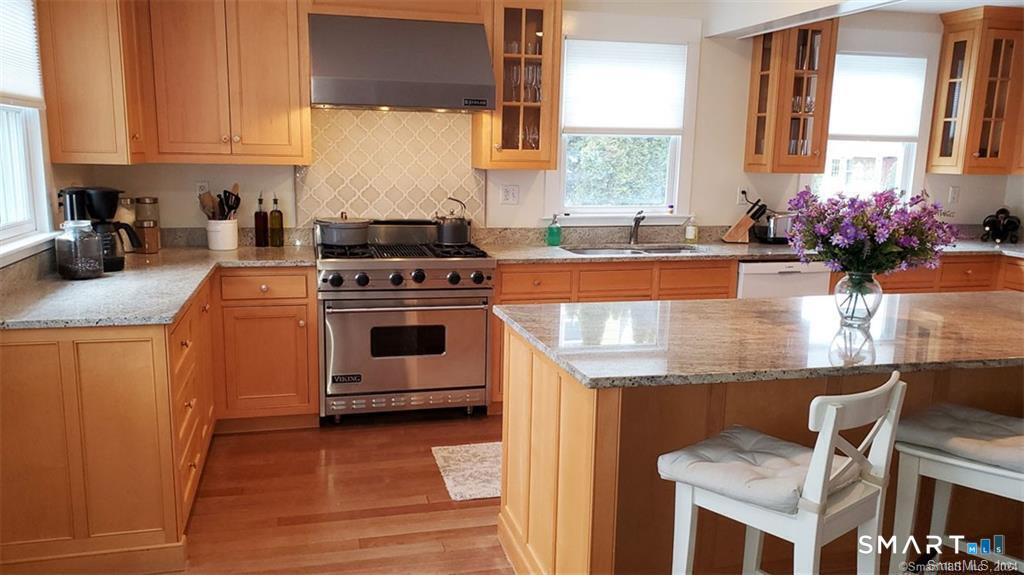 12 Flower Avenue Madison, CT 06443 - Photo 22 of 24 a kitchen with stainless steel appliances granite countertop a stove a sink and a microwave
