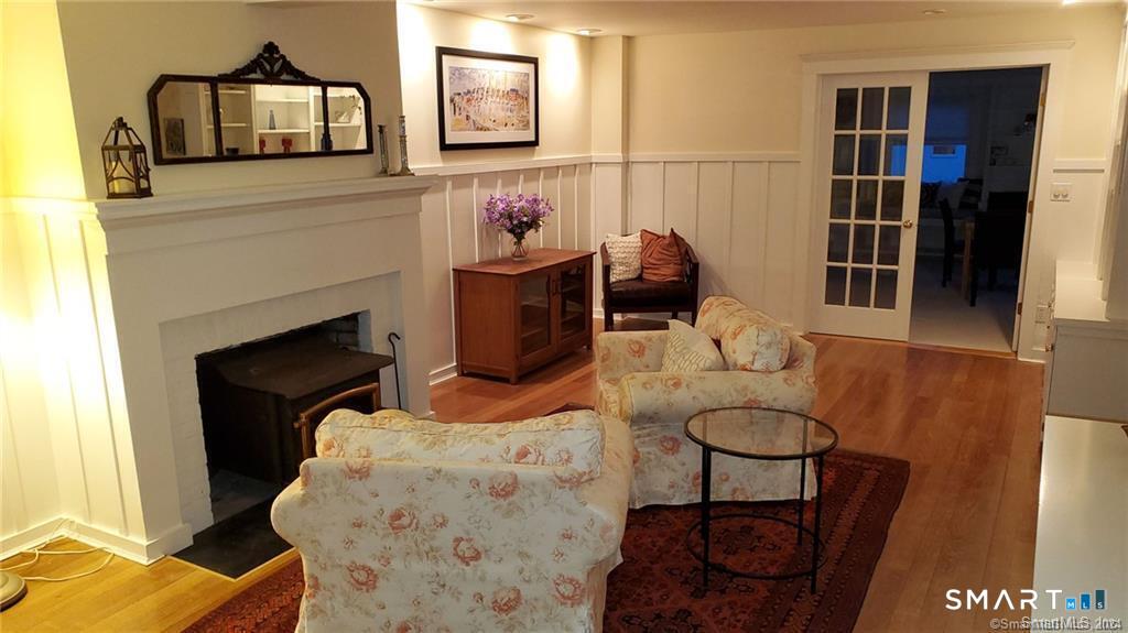 12 Flower Avenue Madison, CT 06443 - Photo 23 of 24 a living room with furniture a flat screen tv and a fireplace