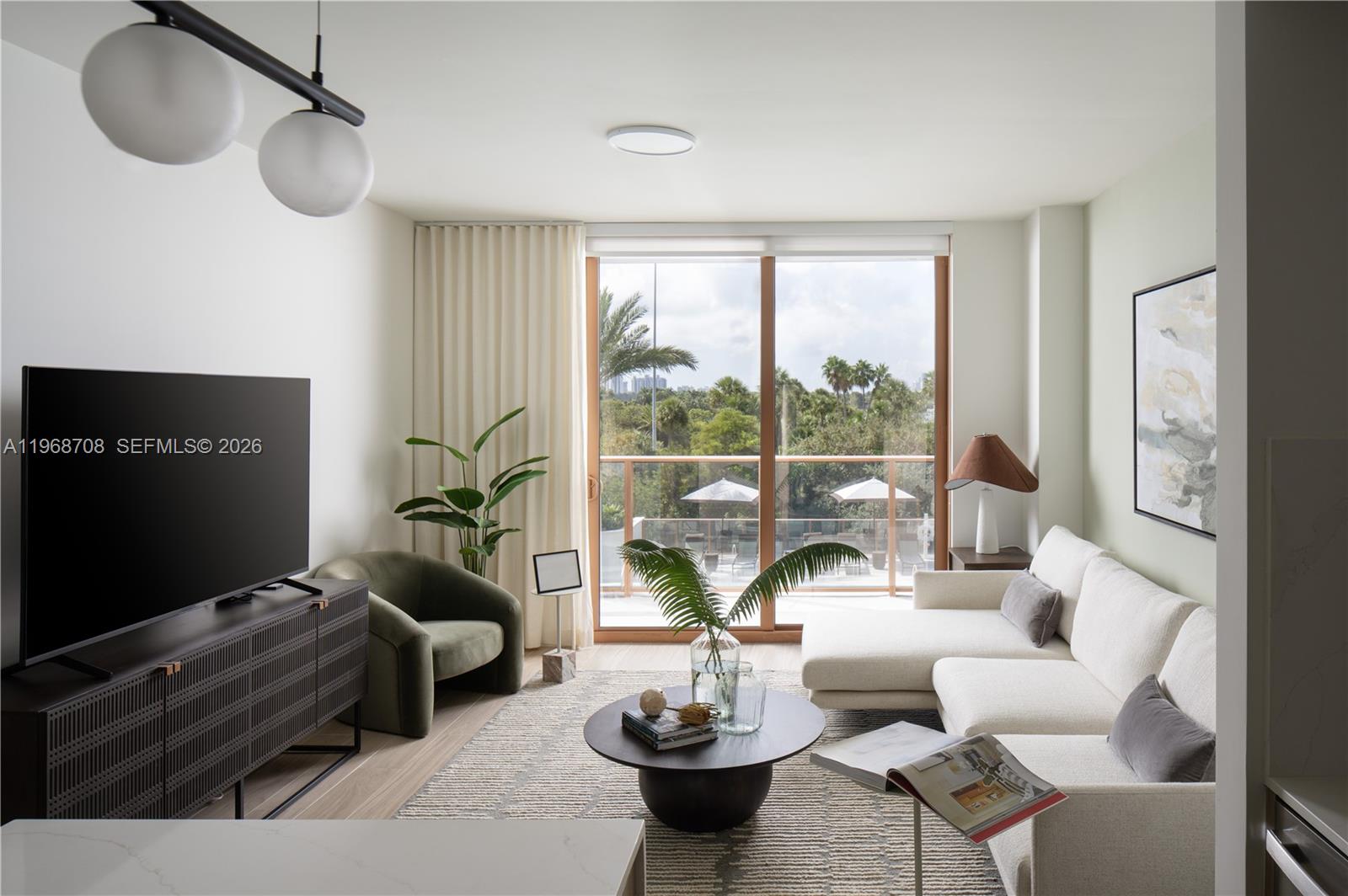 3900 Alton Road, Unit 719 Miami Beach, FL 33140 - Photo 6 of 16 a living room with furniture a window and a flat screen tv