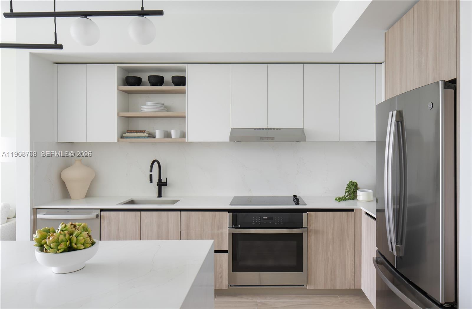 3900 Alton Road, Unit 719 Miami Beach, FL 33140 - Photo 8 of 16 a kitchen with stainless steel appliances a refrigerator a sink and cabinets
