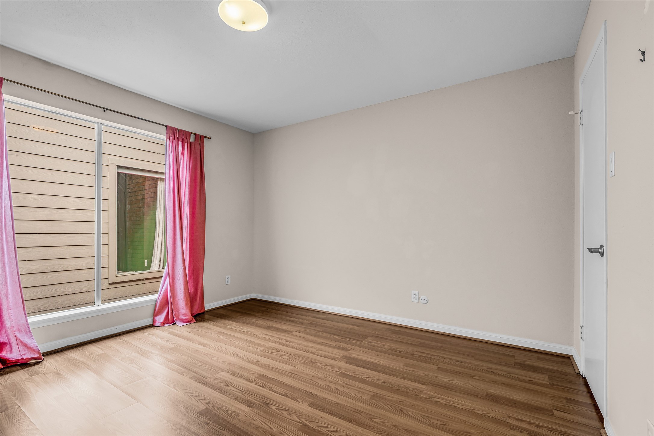 7485 Brompton Street, Unit 7485 Houston, TX 77025 - Photo 31 of 43 Secondary bedroom features a large window allowing natural light to fill the space and has access to a shared bathroom, creating a functional layout that provides comfort and privacy for family members or guests.
