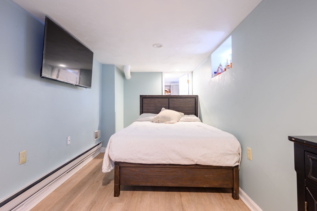 44 Patterson Street Weymouth, MA 02189 - Photo 21 of 27 a bed sitting in a bedroom next to a window with pc on the wall