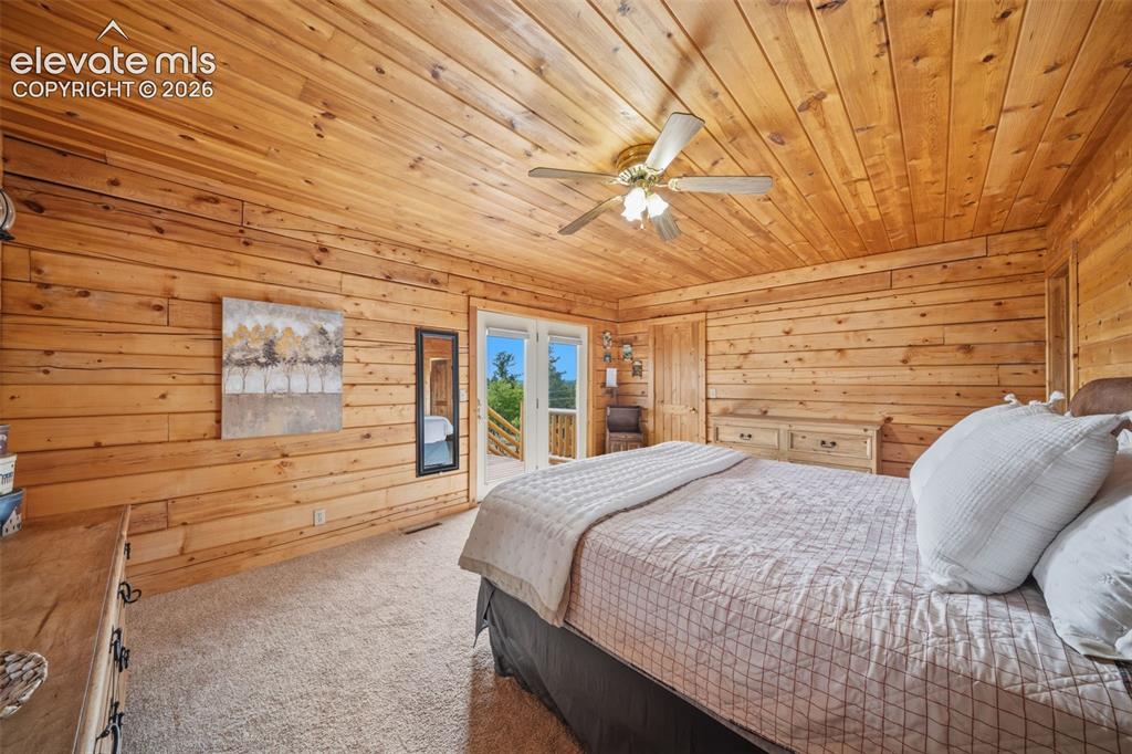 4269 Cedar Mountain Road Divide, CO 80814 - Photo 12 of 39 Main level primary bedroom with walk out to deck, views, walk in closet, ensuite and tongue and groove ceilings and walls