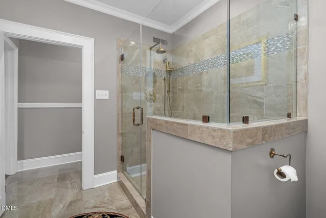 a view of a house with brick walls plants and large tree