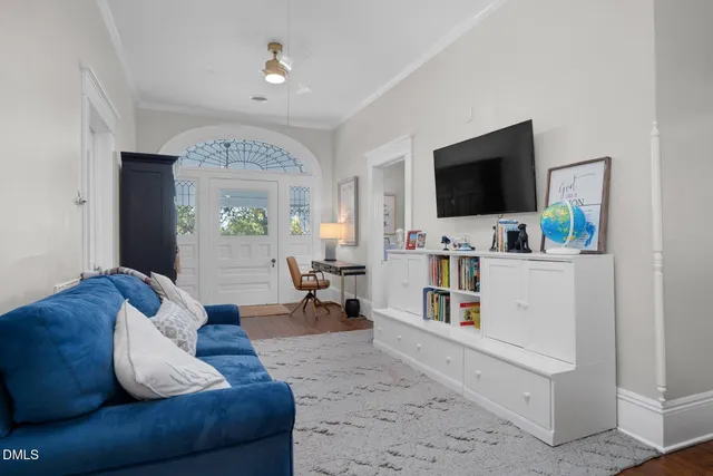 a view of a backyard with table and chairs potted plants and a large tree