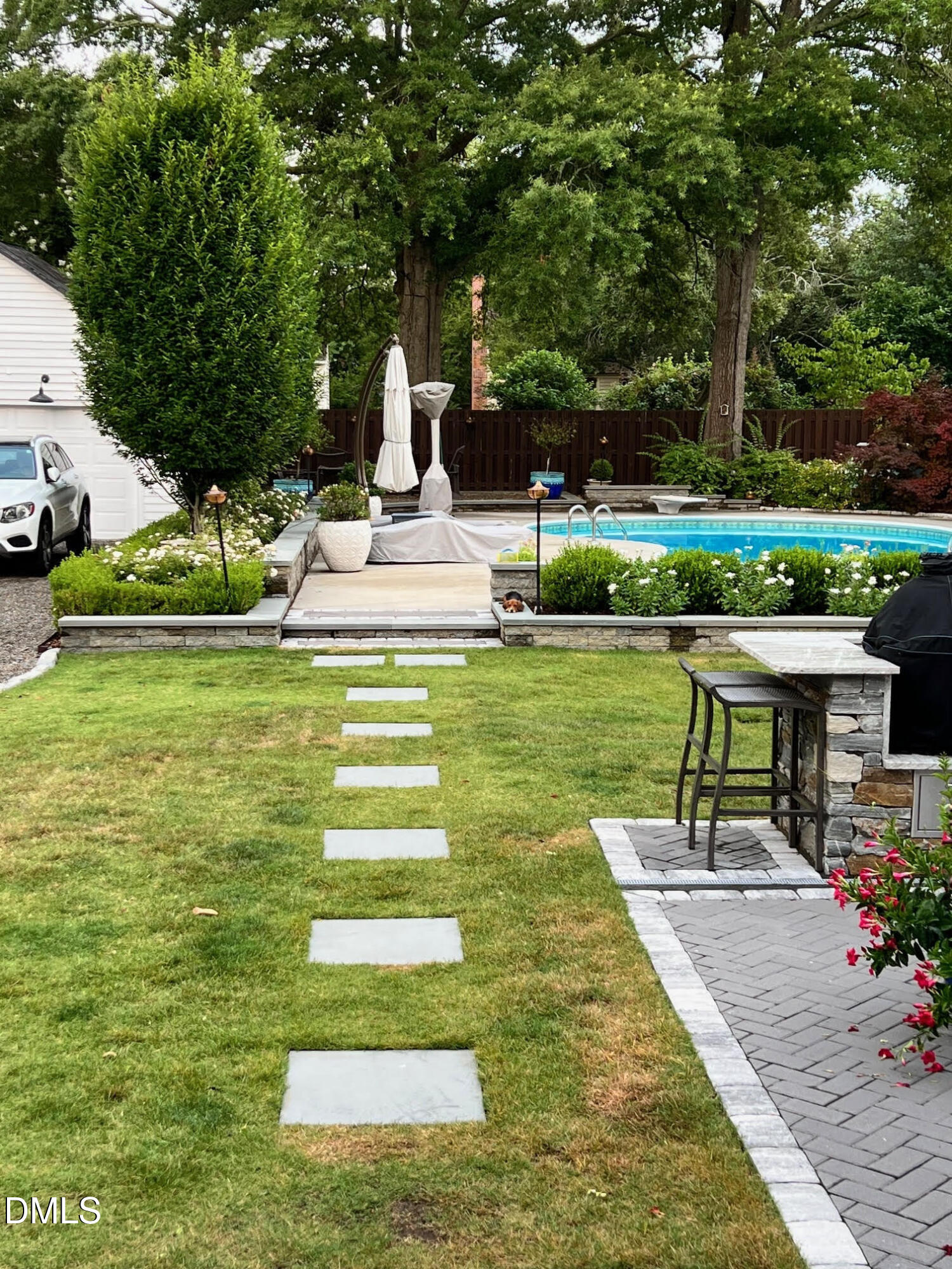 1109 North Main Street Tarboro, NC 27886 - Photo 75 of 90 a view of a swimming pool with lawn chairs plants and large trees